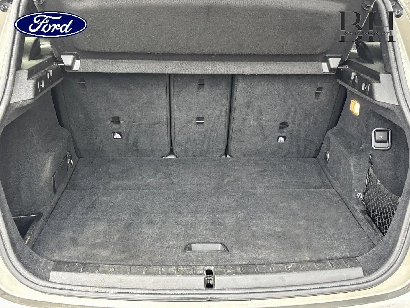 Coffre ouvert d’un BMW Série 2 Active Tourer 216dA 2015, intérieur tissu anthracite avec filet de rangement côté droit.