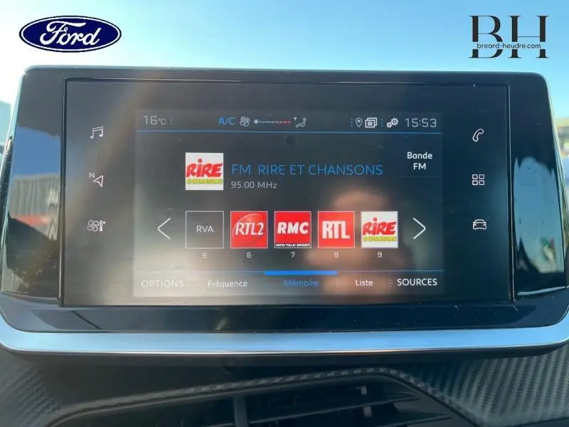 Écran tactile central affichant les stations radio FM dans l'habitacle d'une Peugeot 208 Affaire blanc Banquise, vue de face.