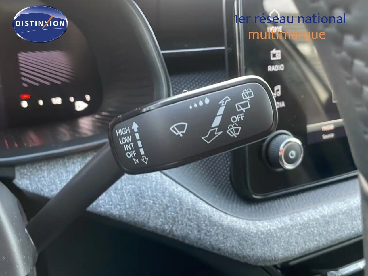 Gros plan sur la manette d’essuie-glace dans l’habitacle d’une Skoda Kamiq gris argent, avec tableau de bord en arrière-plan.