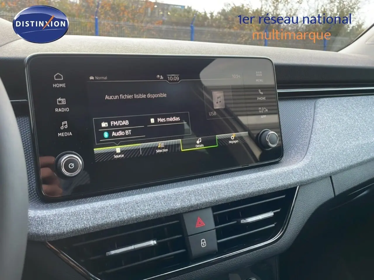 Vue intérieure du tableau de bord du Skoda Kamiq gris argent, avec écran tactile multimédia et commandes centrales visibles.