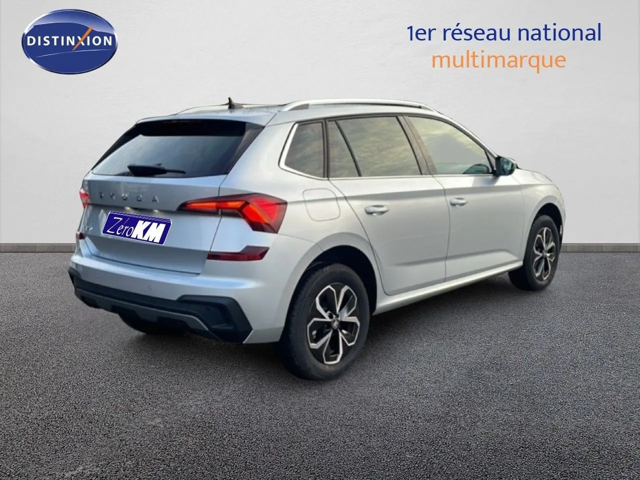 Vue 3/4 arrière droite d'un Skoda Kamiq gris argent métallisé avec jantes bi-ton et vitres teintées.