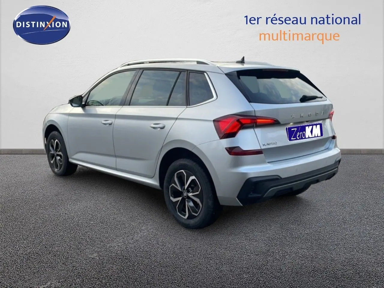 Vue 3/4 arrière droite d’un Skoda Kamiq gris argent métallisé avec jantes bi-ton et feux LED distinctifs.