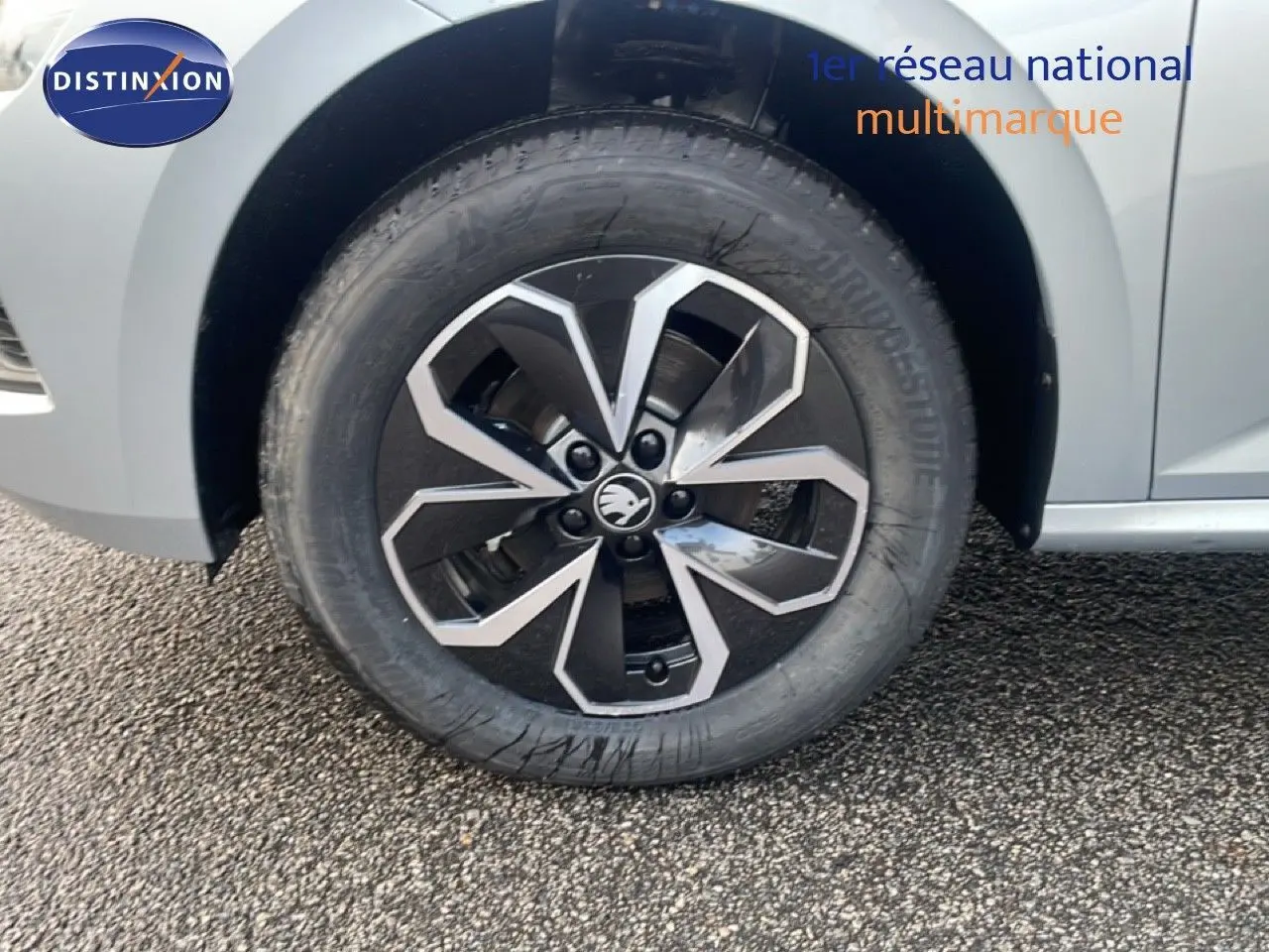 Gros plan sur la roue avant droite d'un Skoda Kamiq gris argent métallisé avec jante alliage bicolore.