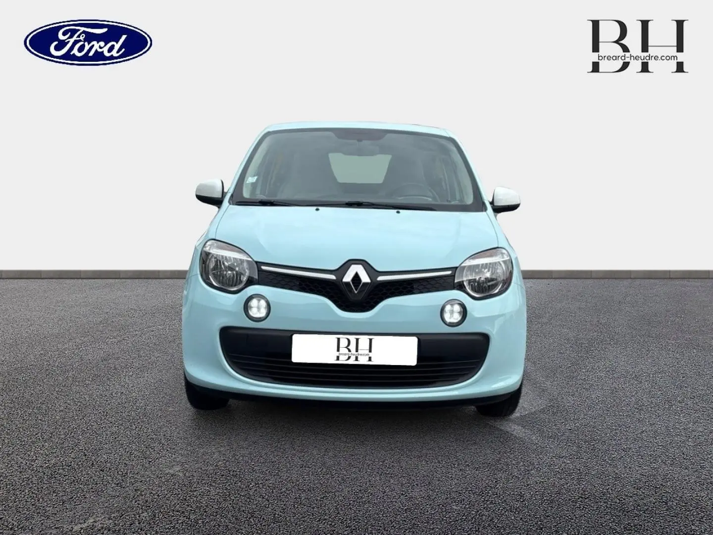 Vue frontale d'une Renault Twingo 1.0 SCe 70ch Zen en bleu dragée avec phares ronds et calandre noire.