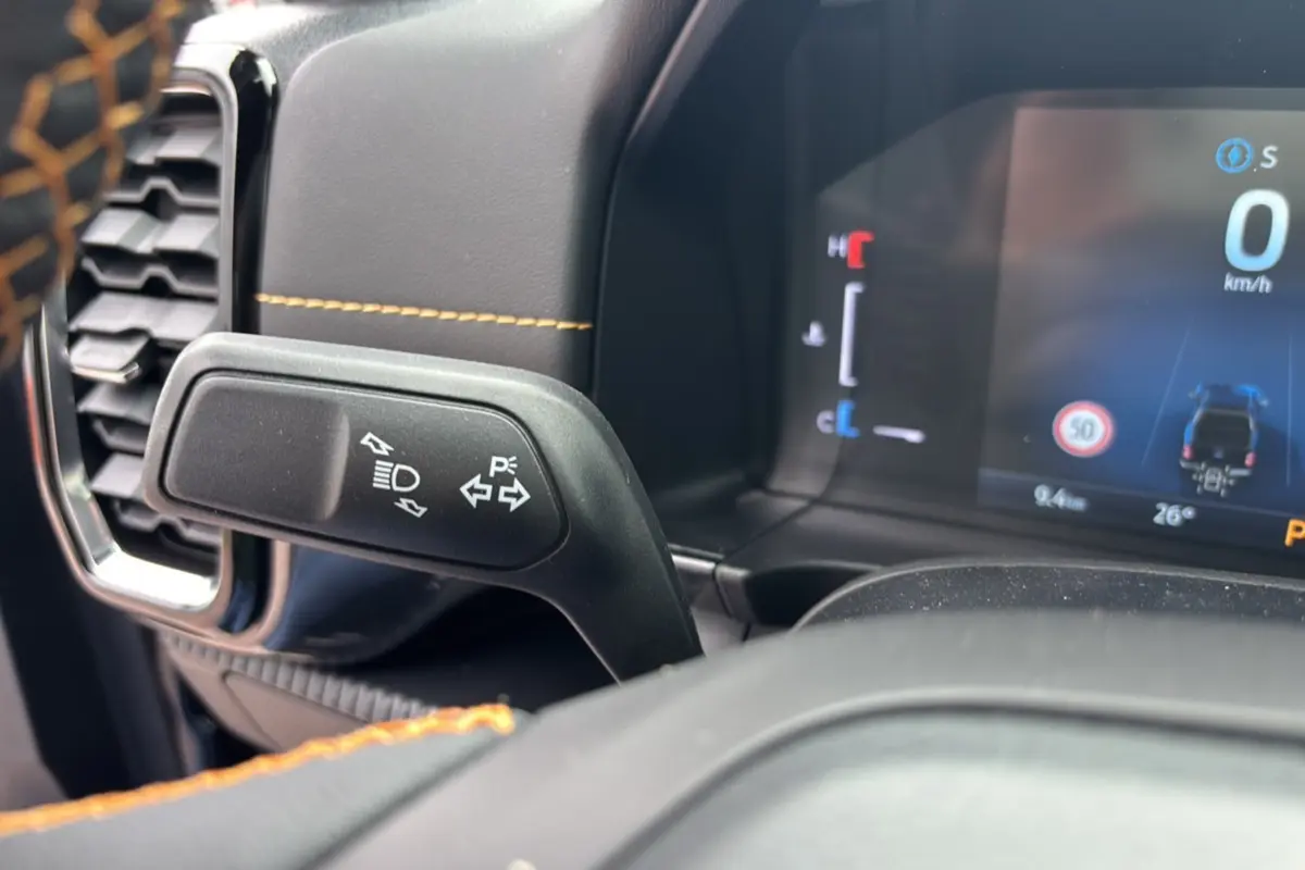 Gros plan sur le commodo de clignotants et tableau de bord numérique du Ford Ranger 2025 noir agate Wildtrak Plus.