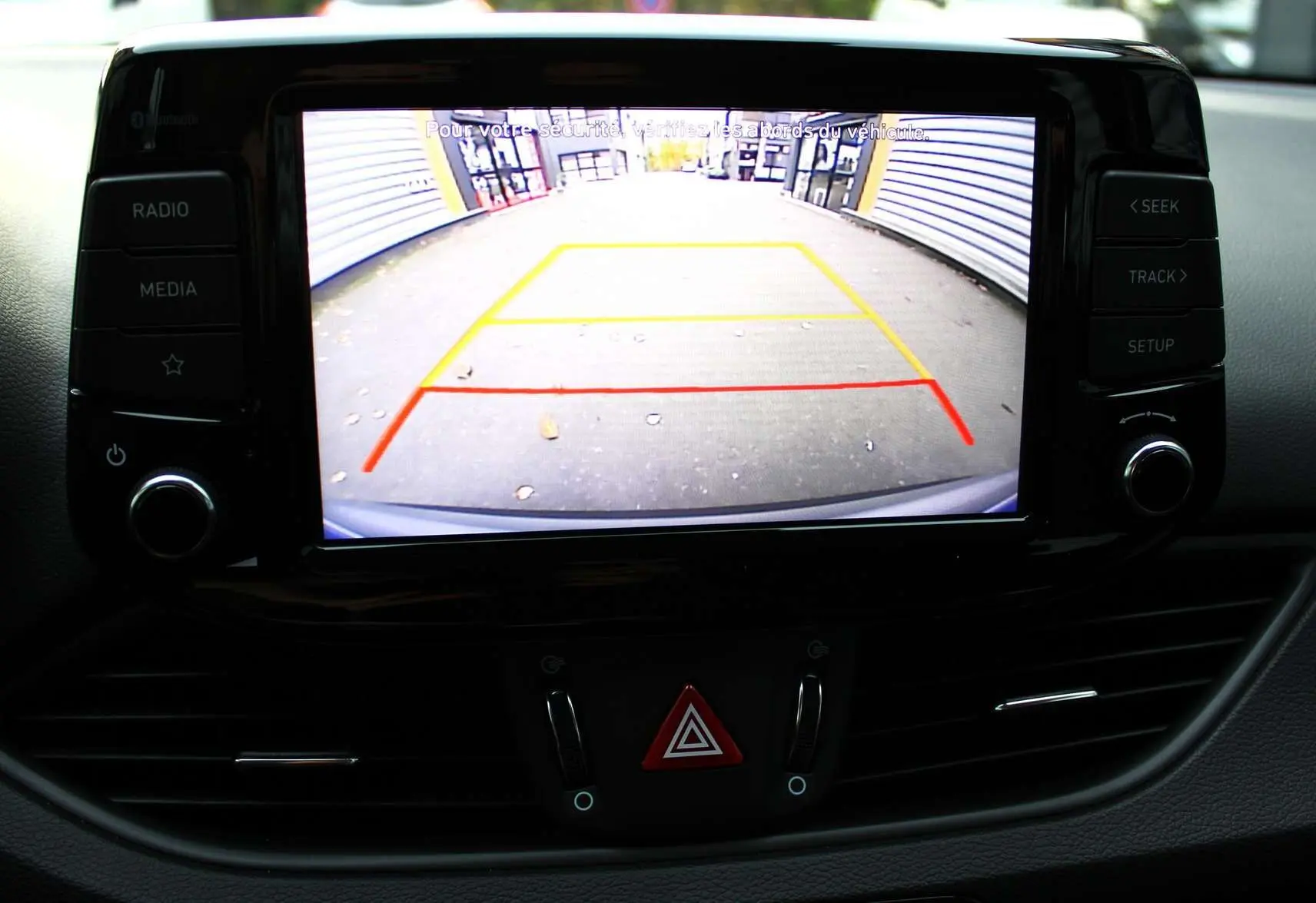 Écran central de la Hyundai i30 SW 2024 affichant la caméra de recul avec les lignes de guidage colorées.