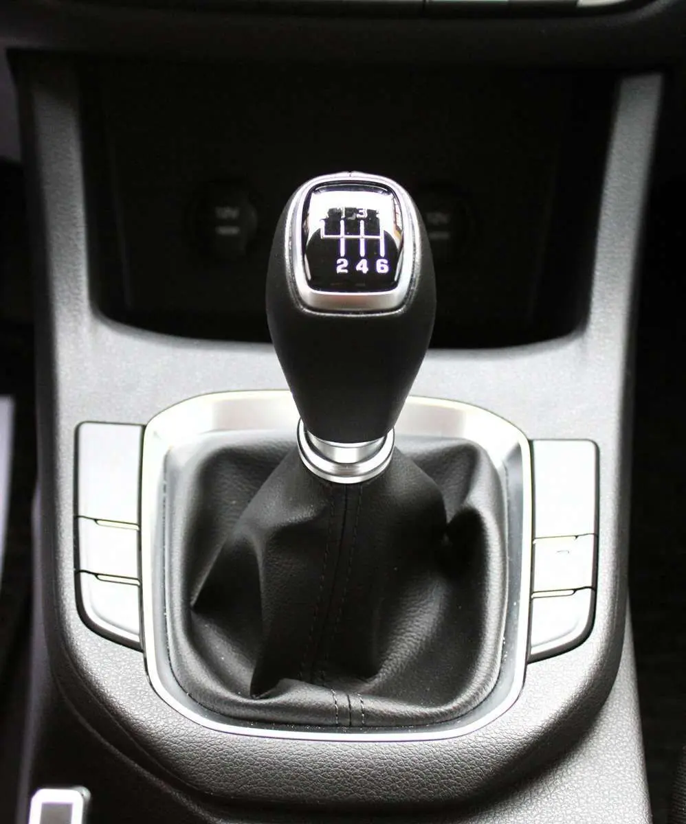 Le levier de vitesses manuel noir de la Hyundai i30 SW 2024, avec indication des six rapports, vu de dessus.