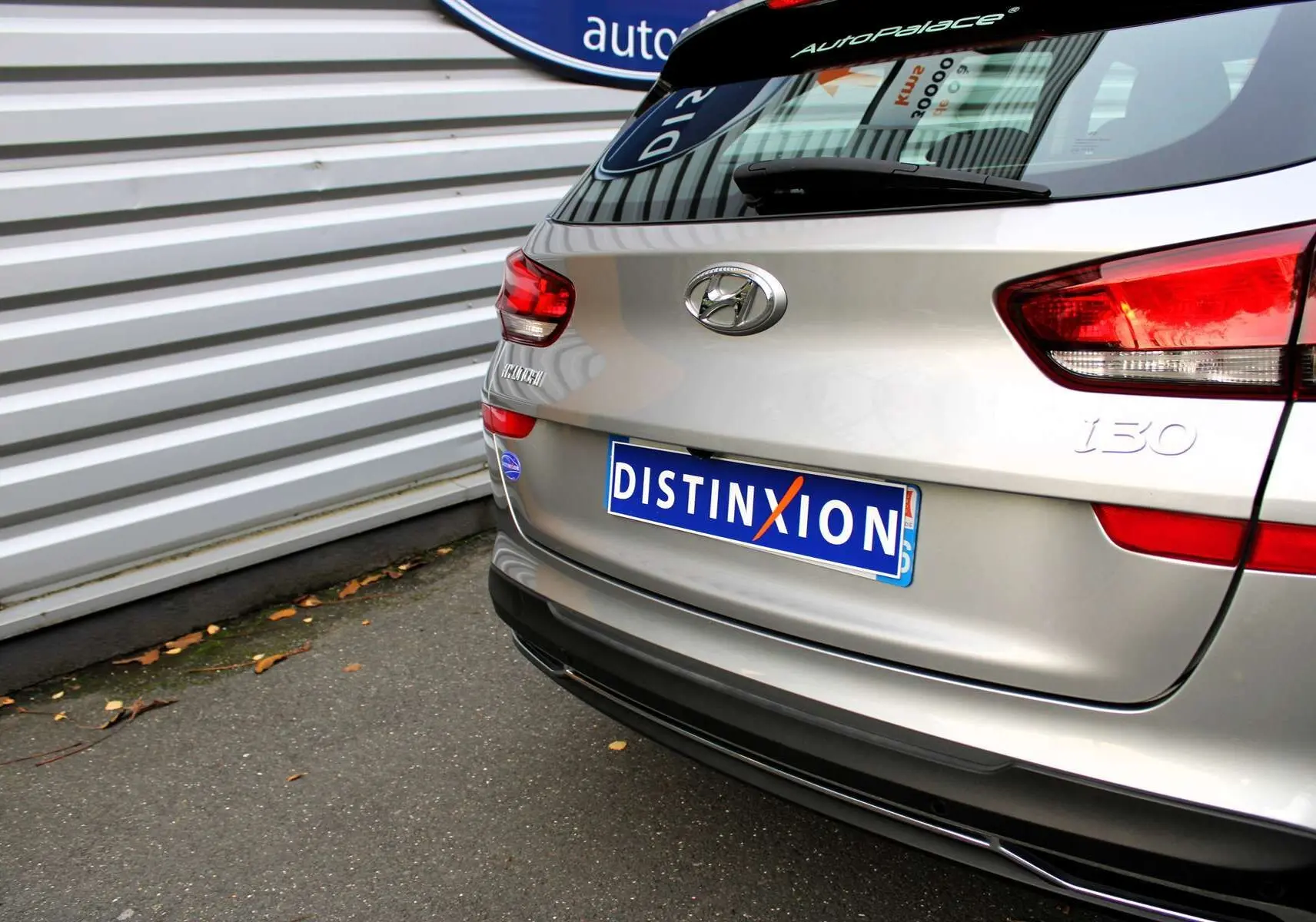 Vue arrière d'une Hyundai i30 SW 2024 en argent scintillant avec plaque Distinxion et feux arrière rouges.
