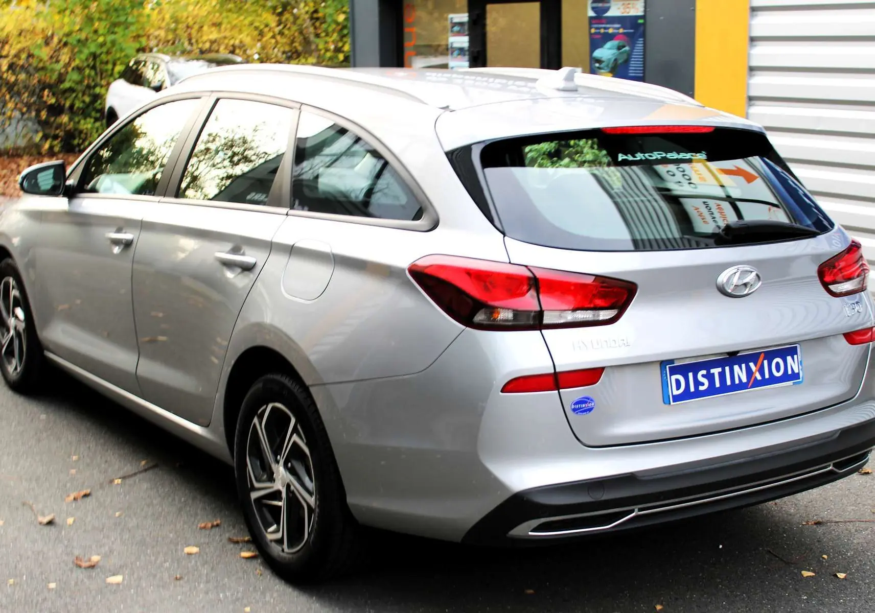 Intérieur côté conducteur de la Hyundai i30 SW 2024 en Shimmering Silver, sièges tissu gris et noir, volant et levier manuel visibles.