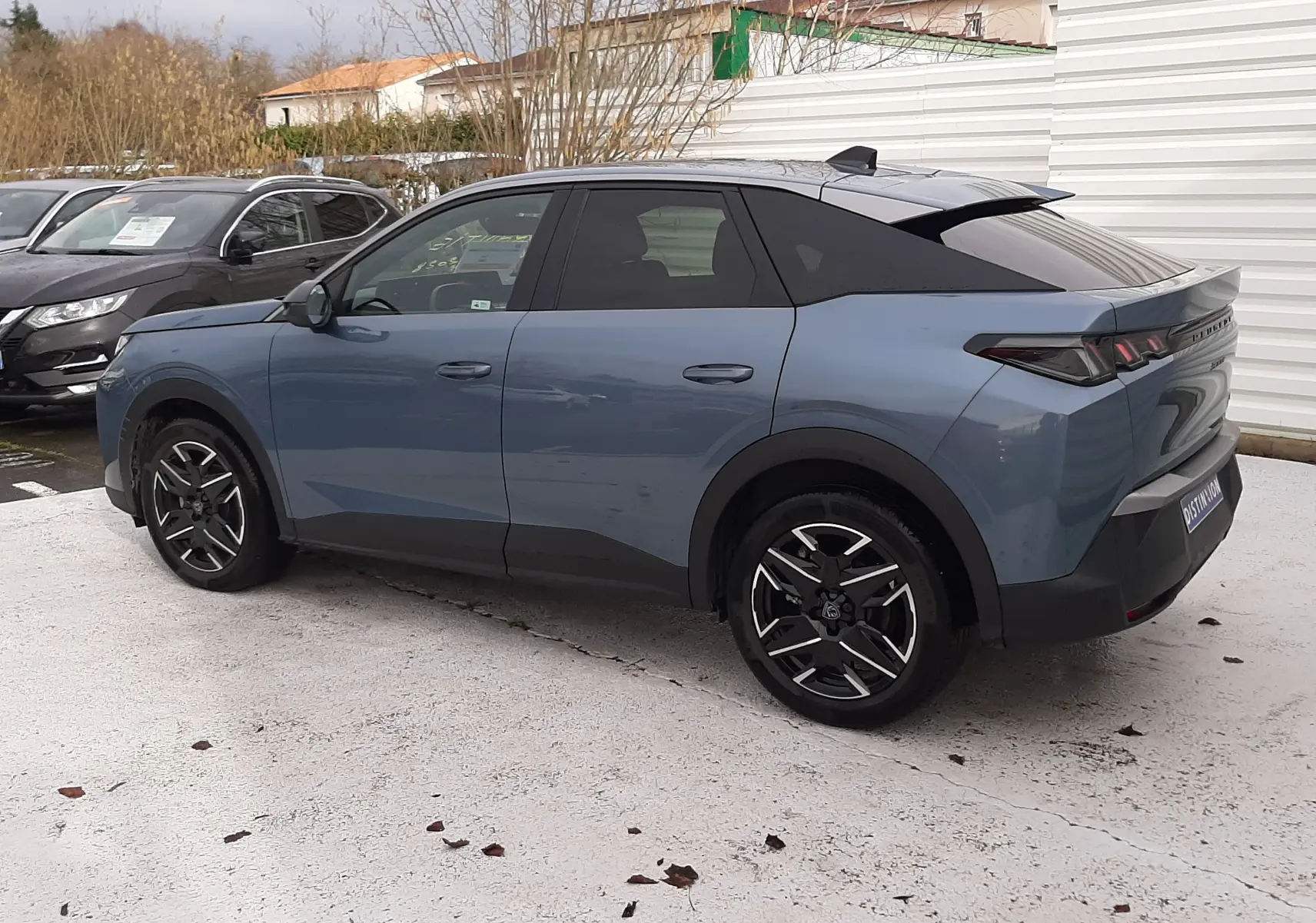 Peugeot 3008 III Hybrid bleu Ingaro vue 3/4 arrière droit, jantes noires et toit noir contrasté.