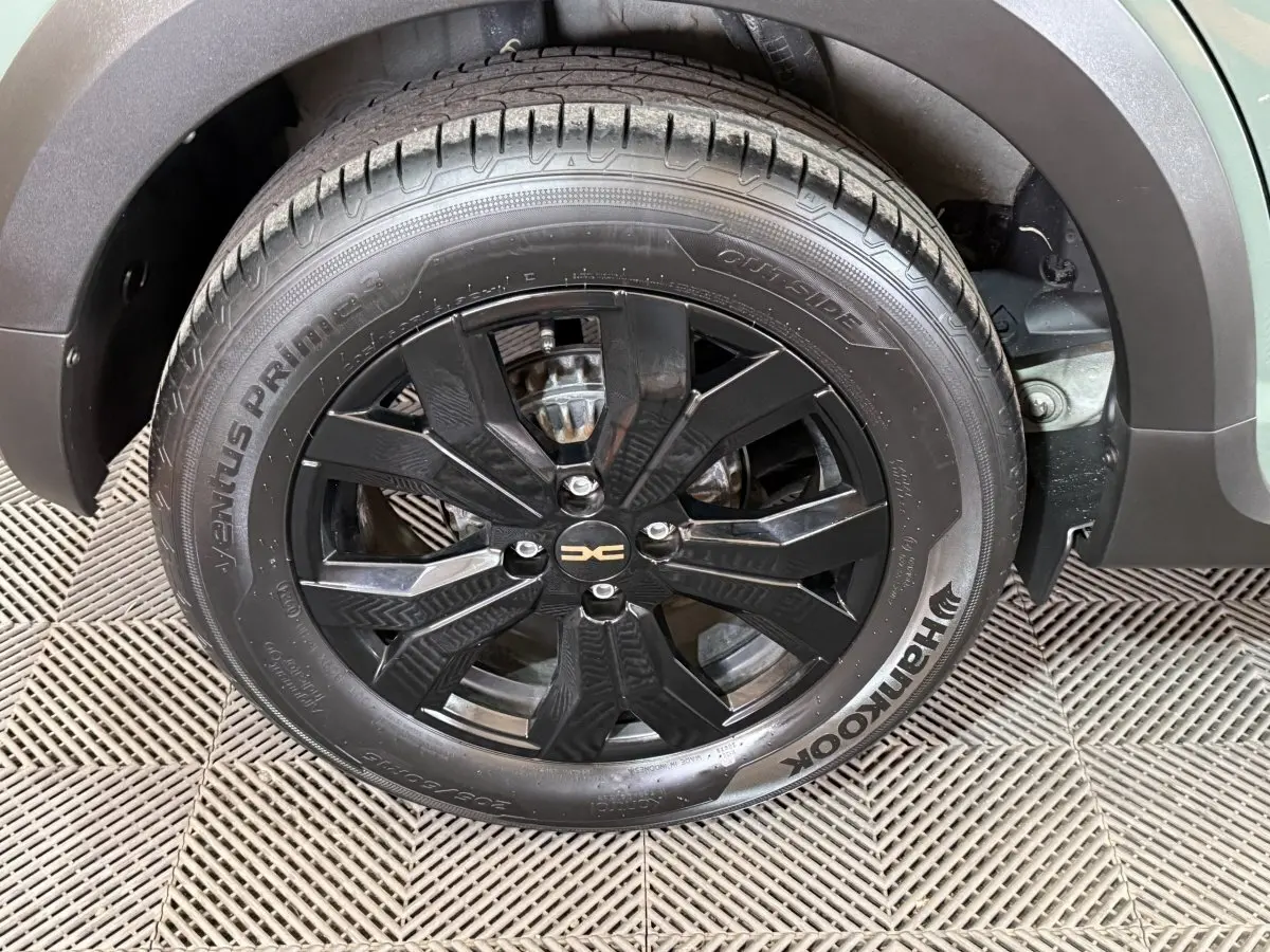 Gros plan sur la roue avant droite noire avec jante alliage du Dacia Sandero Extreme+ vert 2024.