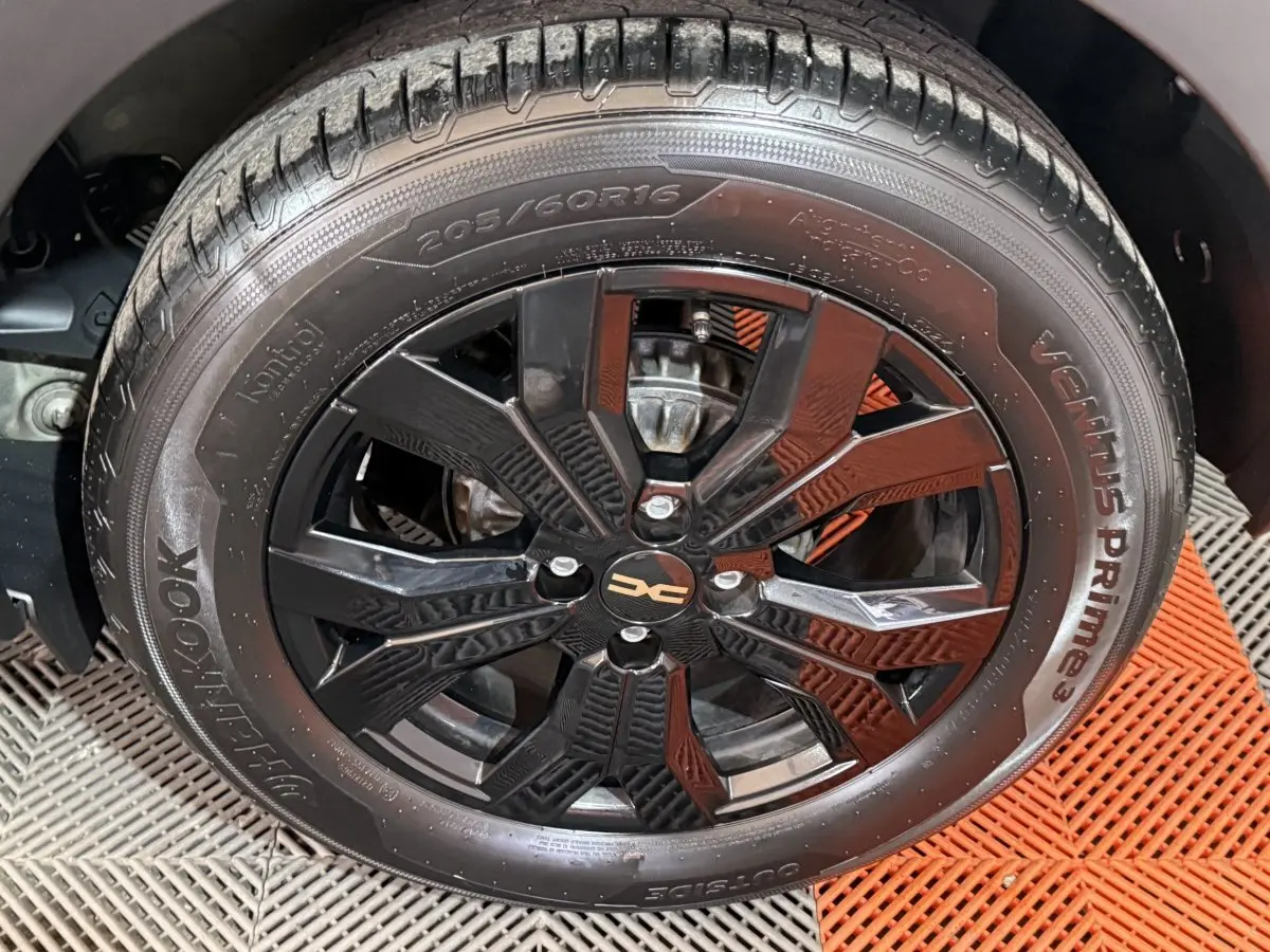 Gros plan sur la roue avant droite de la Dacia Sandero Extreme+ 2024, jante noire brillante avec logo DACIA central.