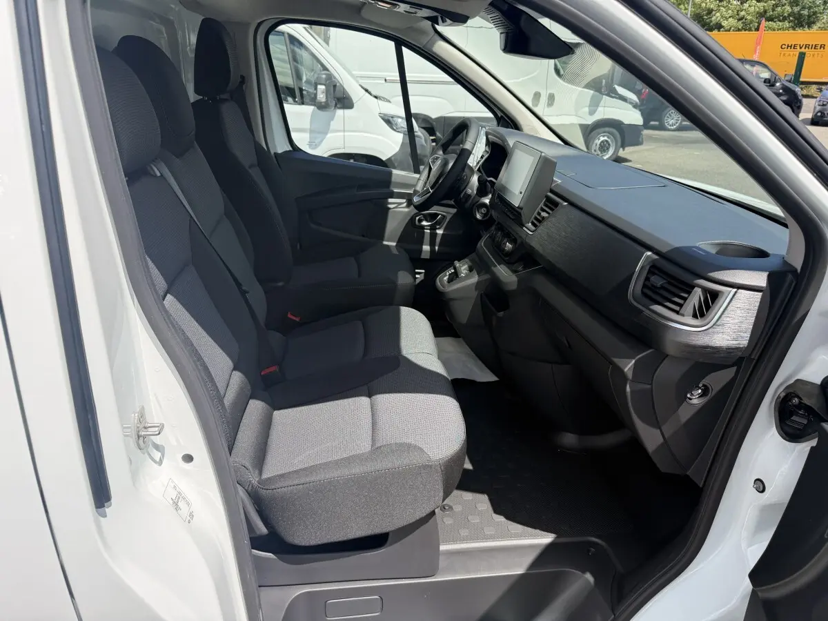 Vue intérieure côté droit du Renault Trafic Fourgon blanc 2025, montrant les sièges avant et le tableau de bord moderne.