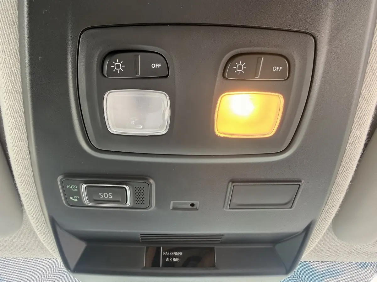 Vue en contre-plongée du plafonnier intérieur du Renault Trafic blanc avec éclairage et bouton SOS activé.