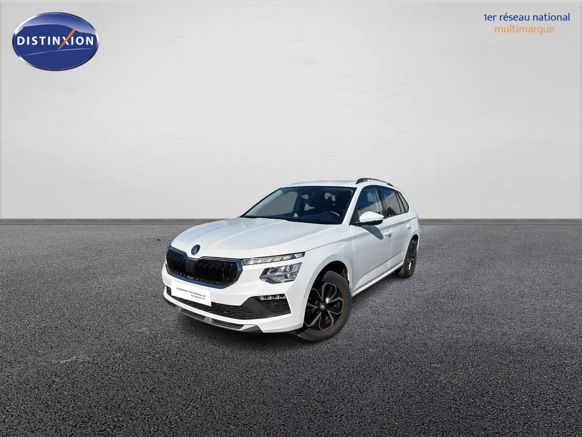 SUV Skoda Kamiq blanc en 3/4 avant droit, avec calandre noire et jantes alliage sombres sur sol gris.