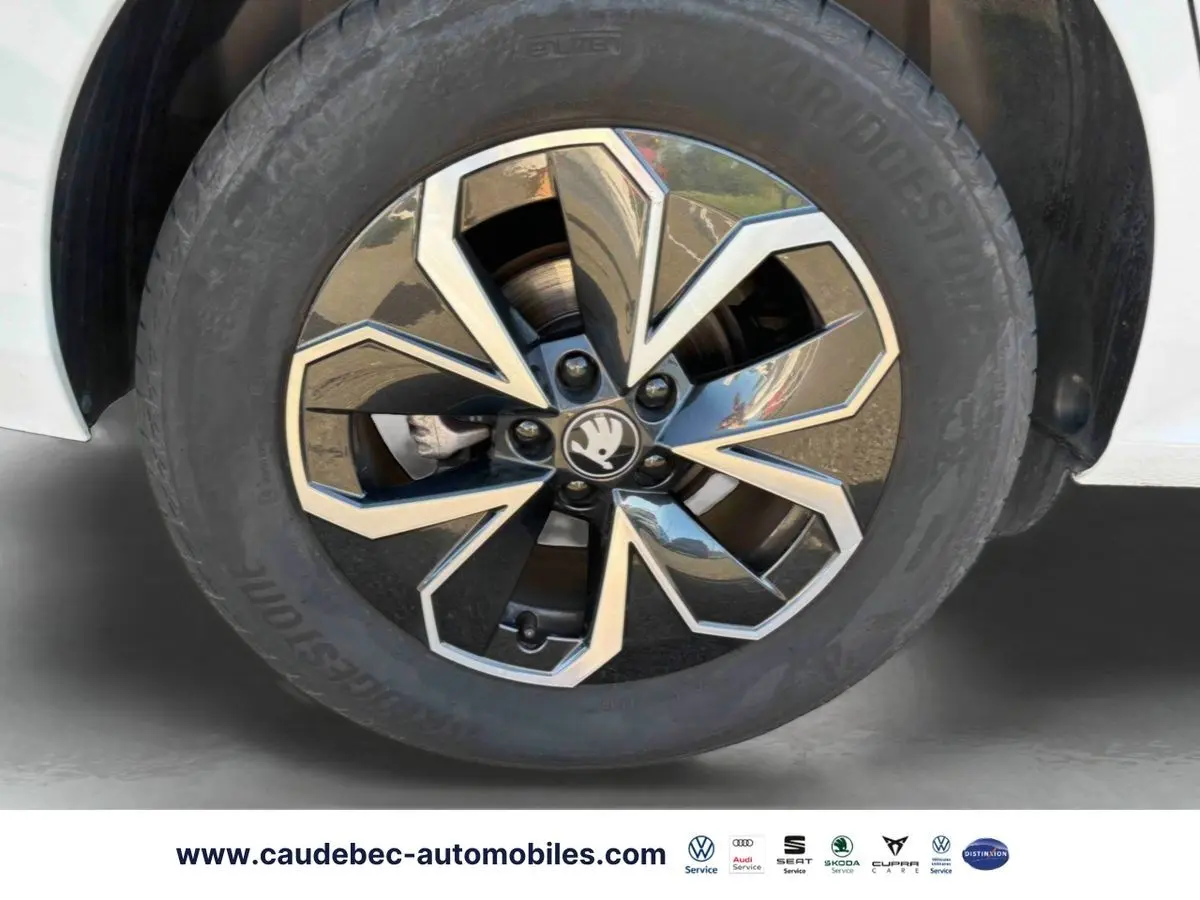 Gros plan sur la jante alliage 16 pouces bicolore du Skoda Kamiq blanc, mettant en valeur le design moderne et le logo central.