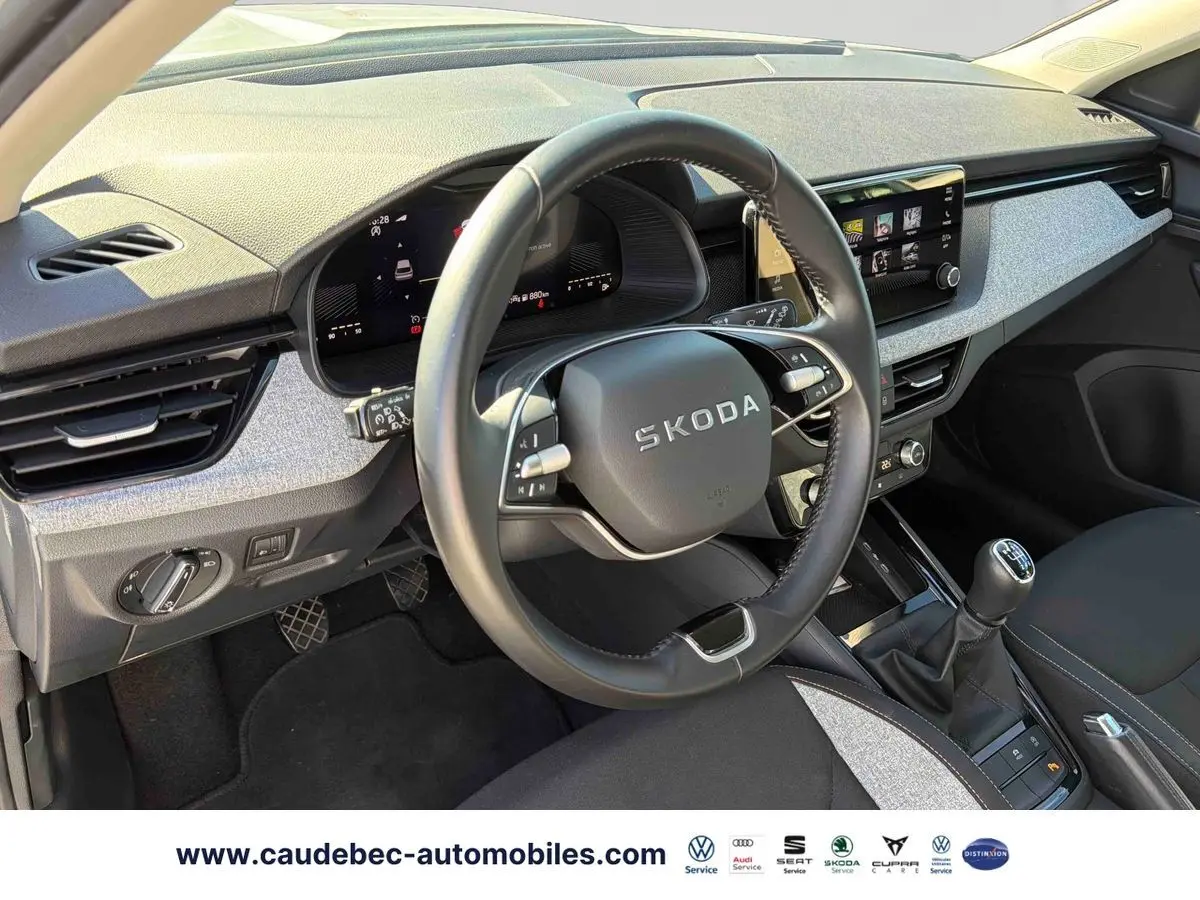Vue intérieure côté conducteur du Skoda Kamiq 2025, volant cuir multifonctions et levier de vitesse manuel visibles.