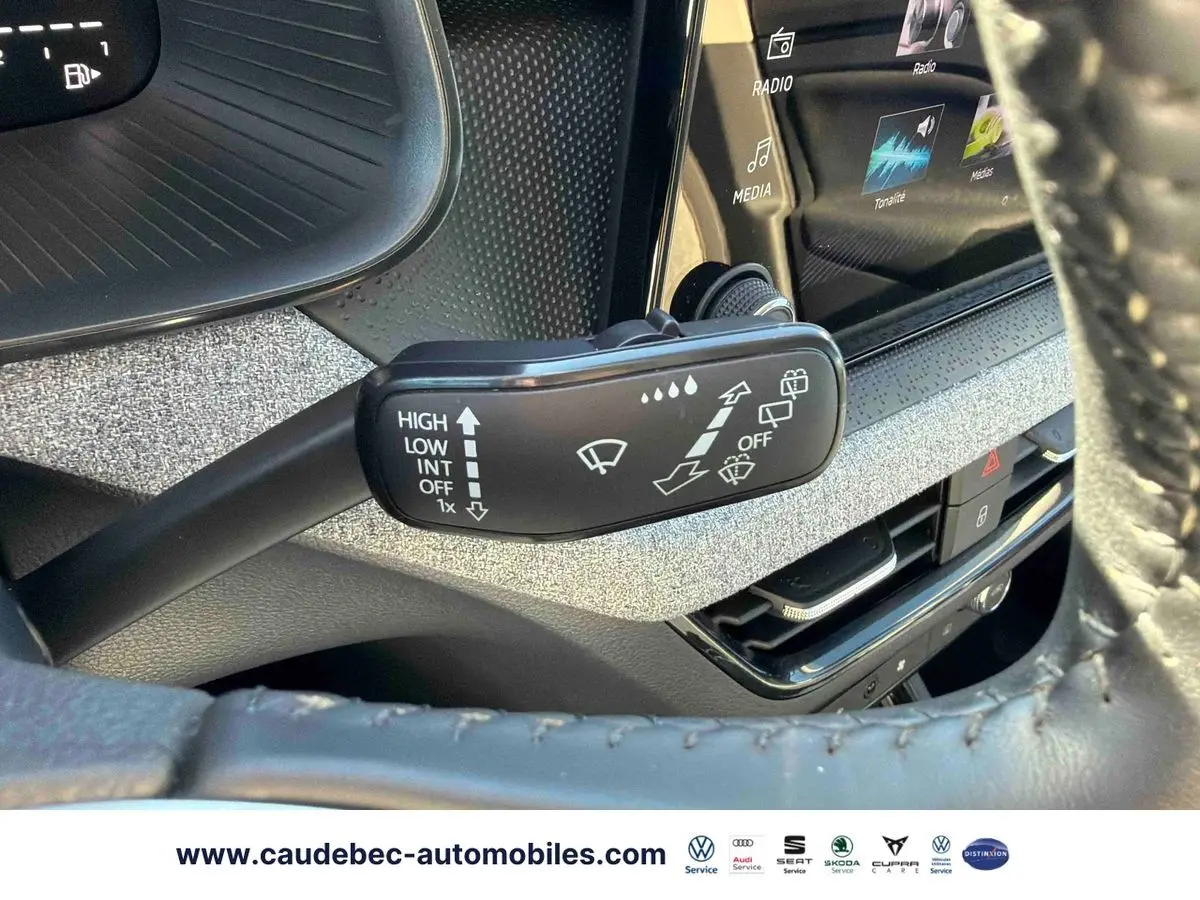 Gros plan sur la commande des essuie-glaces du Skoda Kamiq 2025, avec tableau de bord et écran tactile en arrière-plan.
