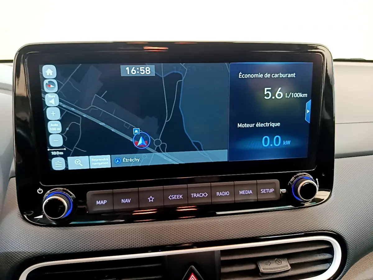 Écran tactile central du tableau de bord du Hyundai Kona noir 2020 affichant navigation et consommation hybride