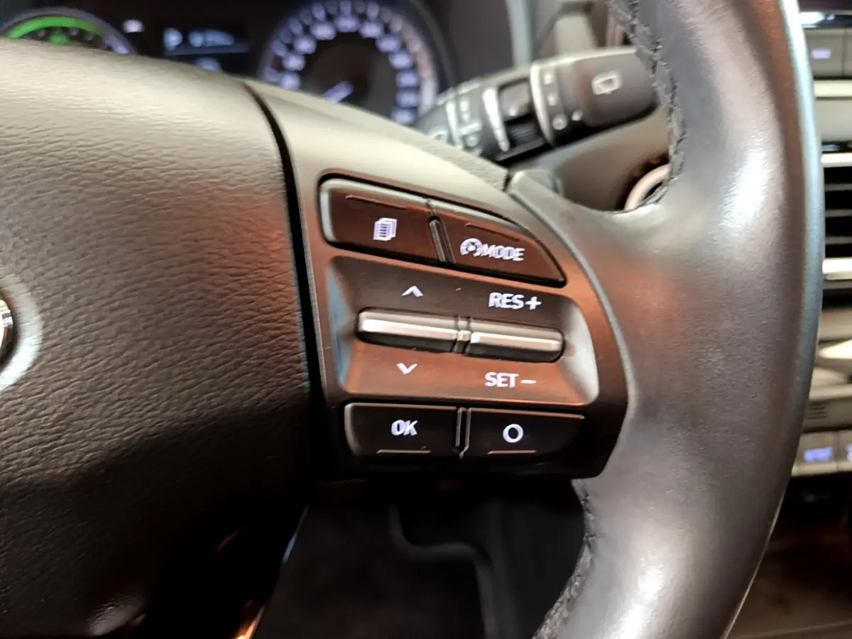 Gros plan sur les commandes du volant cuir du Hyundai Kona 1.6 GDi Hybrid 2020, boutons de régulateur de vitesse visibles.