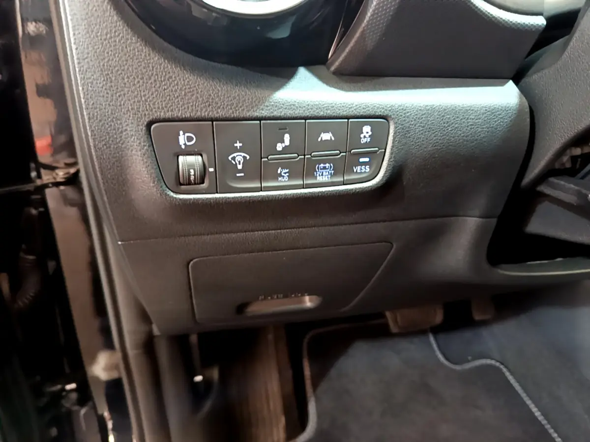 Gros plan sur les commandes de réglage et assistances côté conducteur du tableau de bord noir du Hyundai Kona 2020.