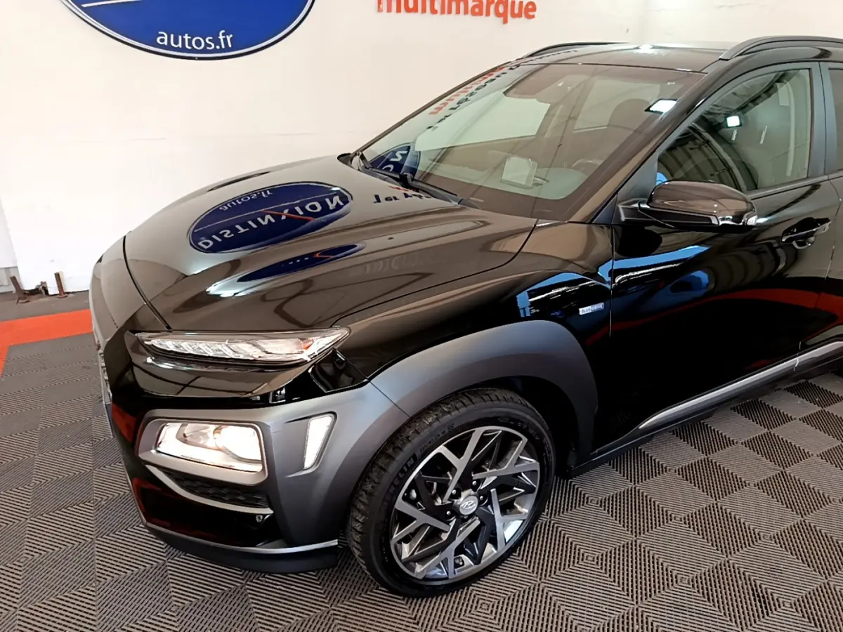 Vue 3/4 avant droite d'un Hyundai Kona noir avec feux allumés et jantes alliage modernes.