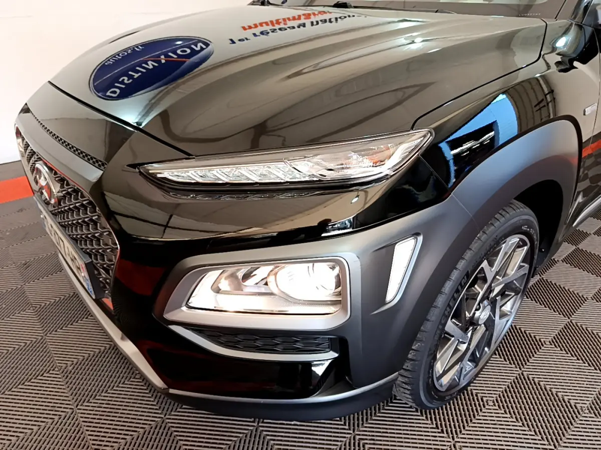 Vue 3/4 avant droit d'un Hyundai Kona noir mettant en valeur ses phares LED et sa calandre distinctive.