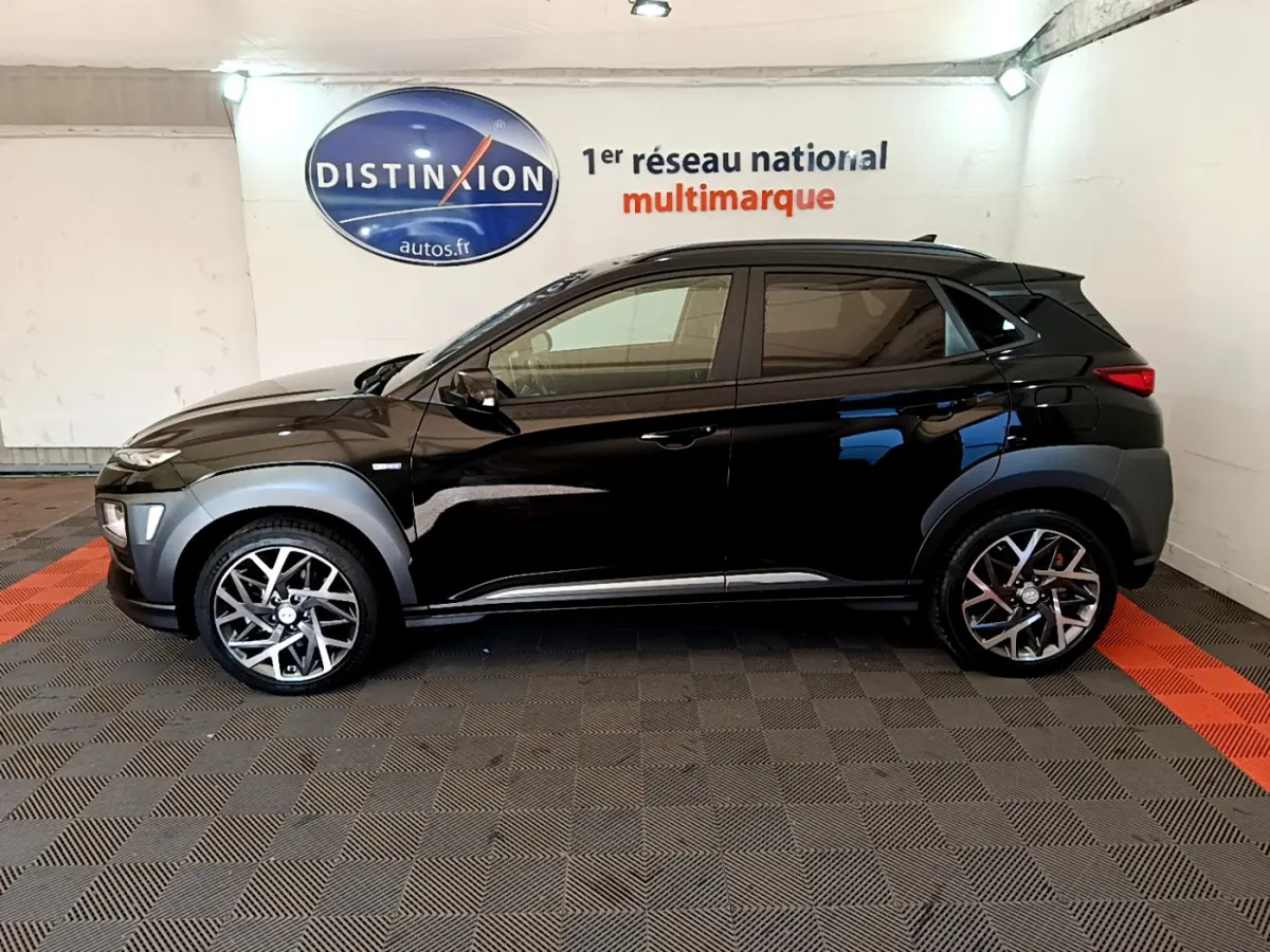 Profil côté gauche du Hyundai Kona noir 2020 avec jantes alliage et protections grises sur les passages de roues.