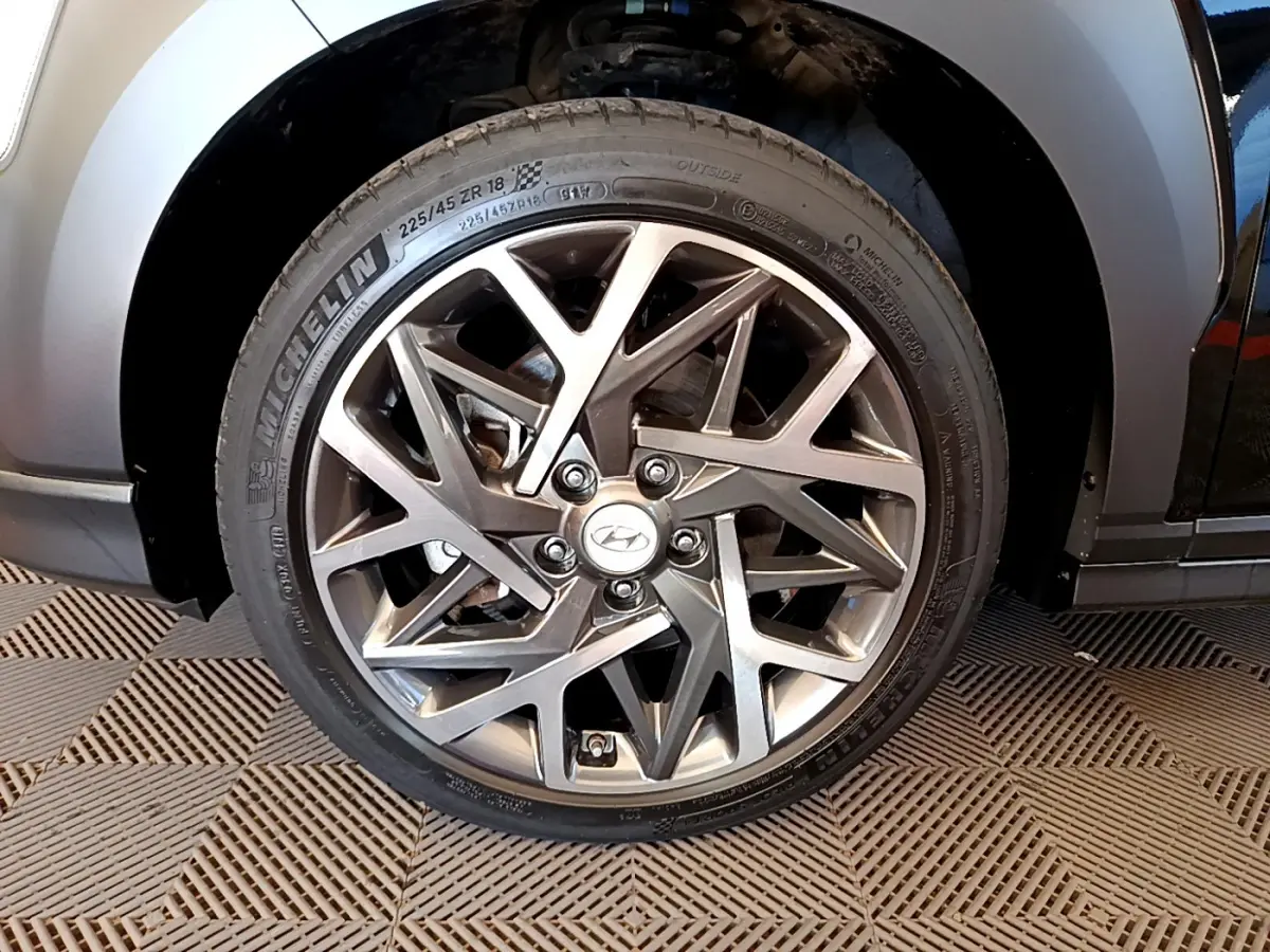 Gros plan sur la roue avant droite du Hyundai Kona noir 2020, mettant en valeur la jante alliage au design géométrique.