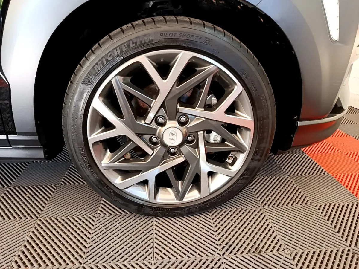 Gros plan sur la roue avant droite du Hyundai Kona noir 2020 avec jante alliage au design géométrique moderne