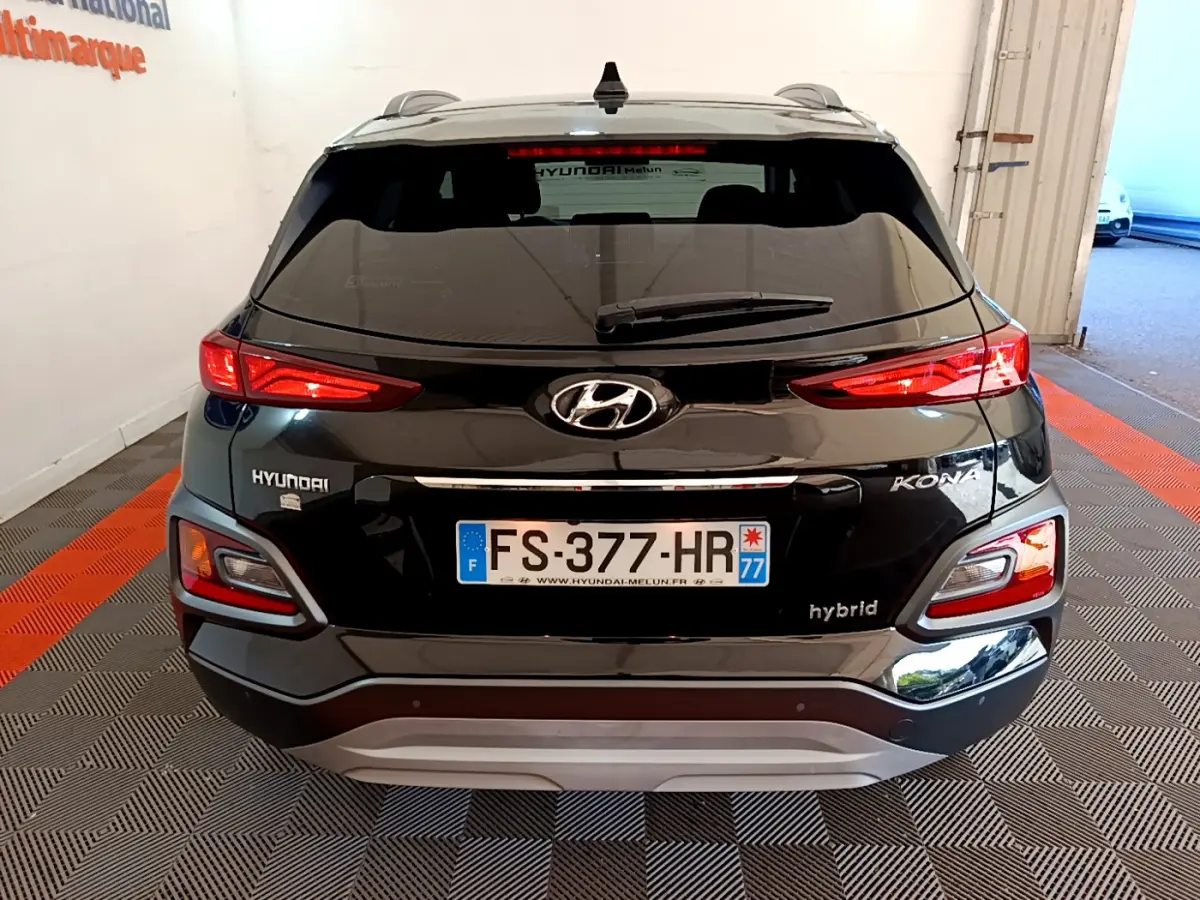 Vue arrière d'un Hyundai Kona noir hybride 2020 avec feux LED et plaques françaises dans un garage.
