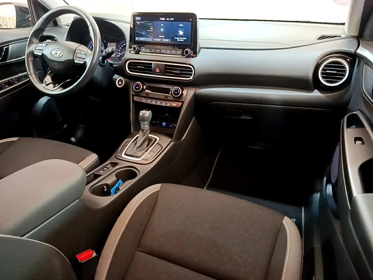 Intérieur avant du Hyundai Kona 1.6 GDi Hybrid 2020, tableau de bord noir avec écran tactile et volant multifonctions.