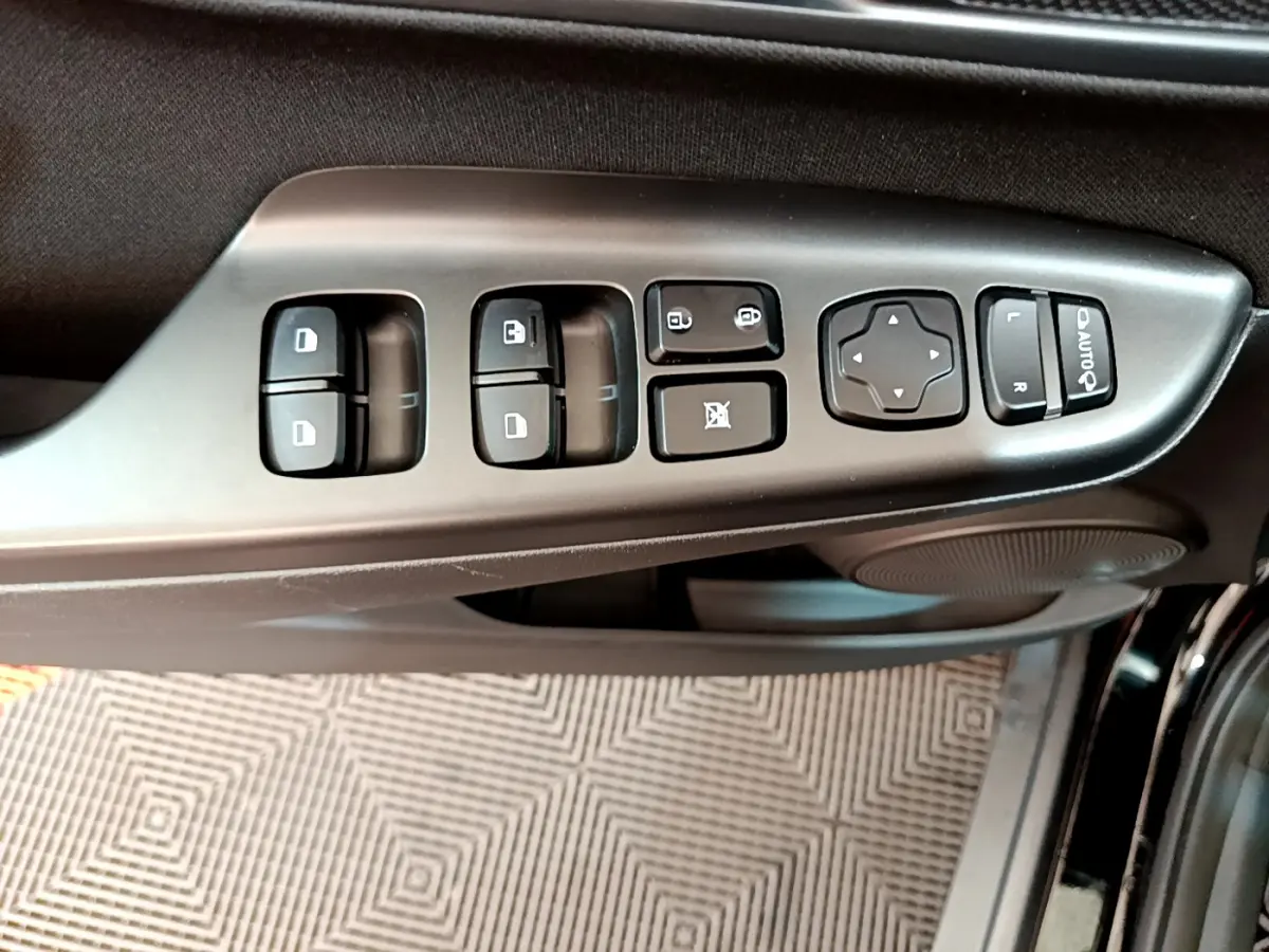 Gros plan sur les commandes de vitres et rétroviseurs côté conducteur du Hyundai Kona noir 2020.
