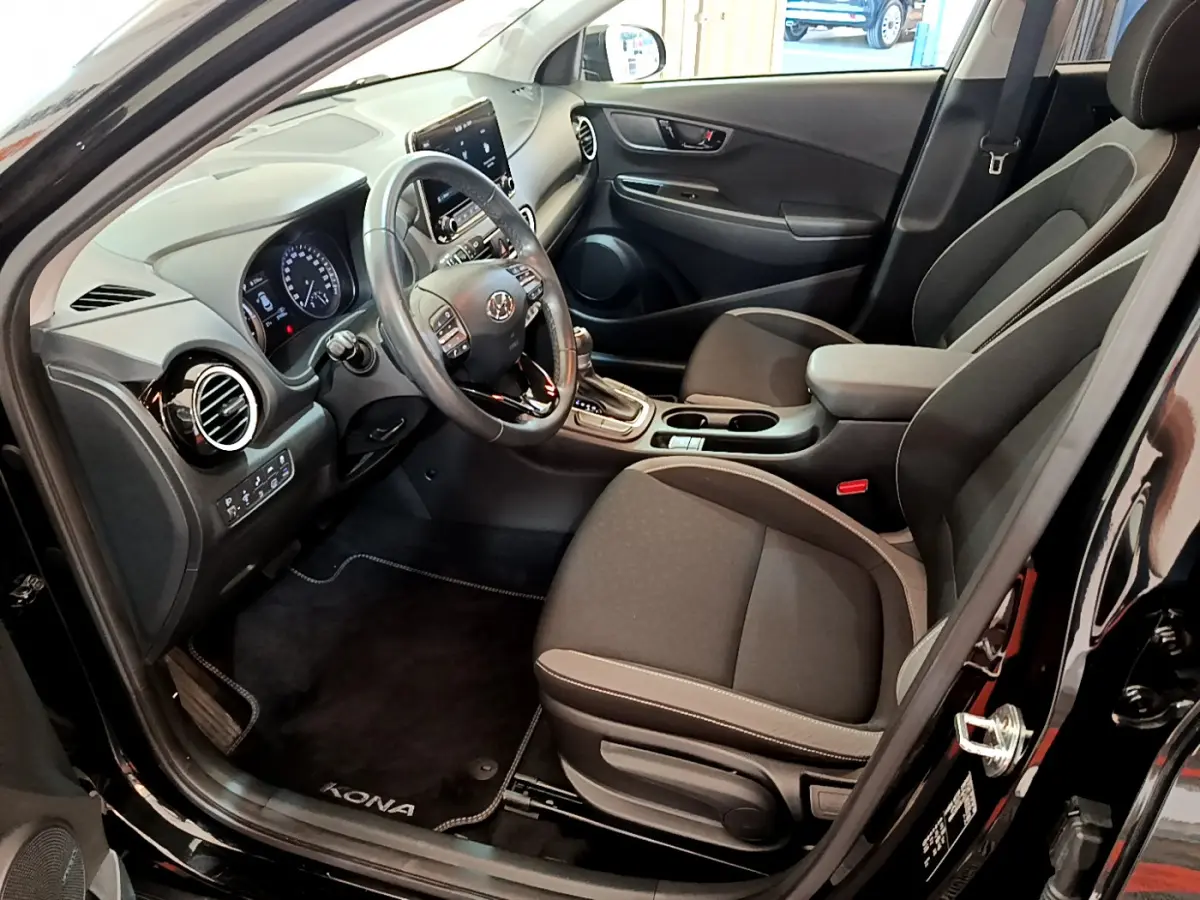 Intérieur côté conducteur du Hyundai Kona noir 2020, avec tableau de bord moderne et sièges tissu gris.