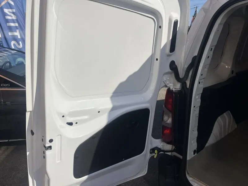 Vue rapprochée de la porte arrière droite blanche banquise ouverte du Citroën Berlingo Fourgon 2020 montrant l'intérieur tôlé.