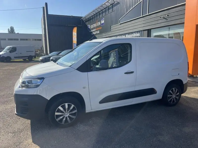 Vue de profil côté gauche d'un Citroën Berlingo Fourgon blanc Banquise avec enjoliveurs et protections noires.