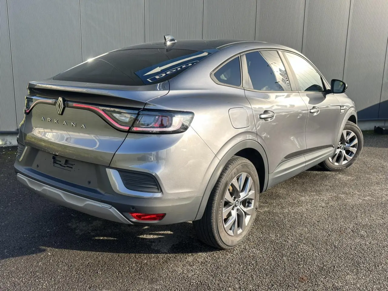 Vue 3/4 arrière droite d'un Renault Arkana gris métallisé avec feux arrière LED et jantes alliage 17 pouces.