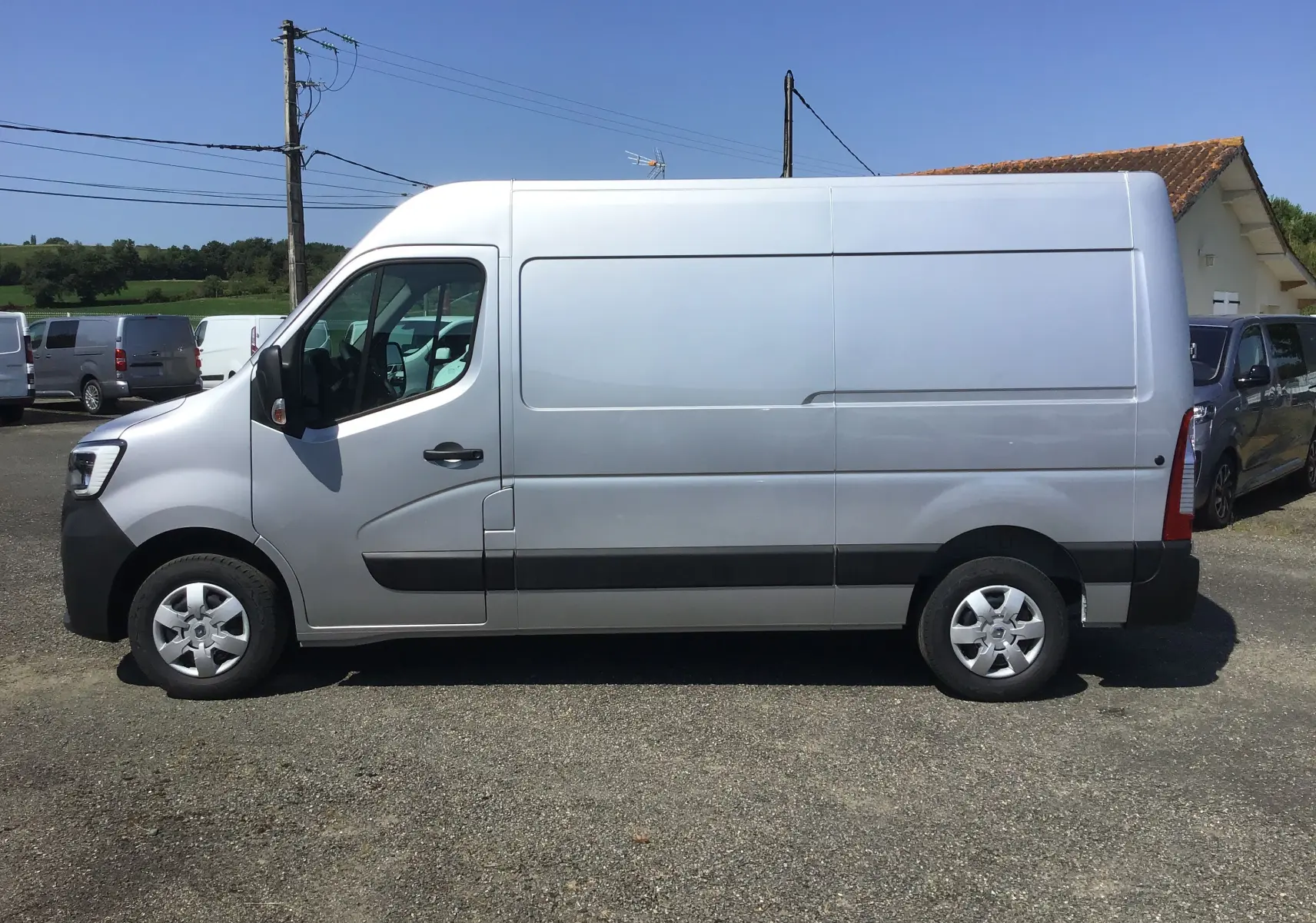 Vue latérale côté gauche d'un Renault Master gris étoile 2024 avec enjoliveurs maxi et grande hauteur de toit.