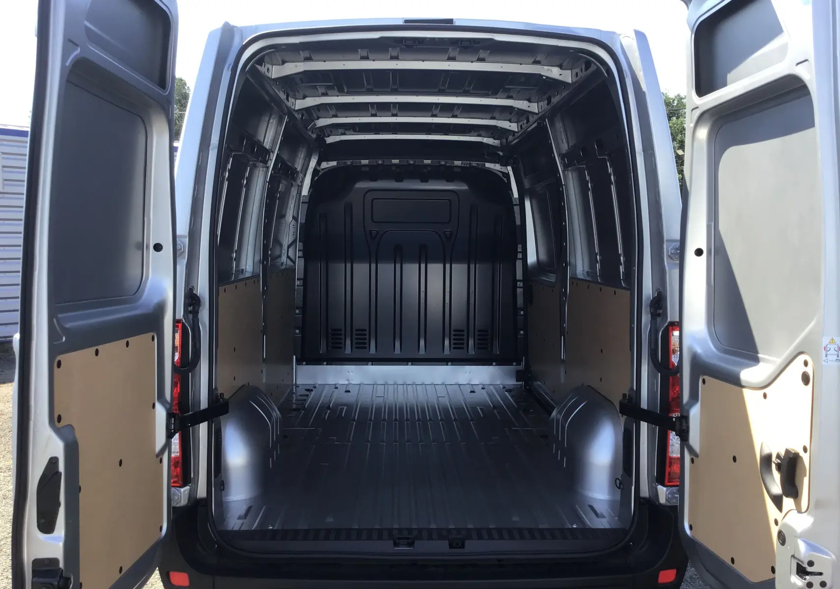 Vue arrière intérieure du Renault Master gris étoile 2024, montrant la grande zone de chargement vide avec portes ouvertes.