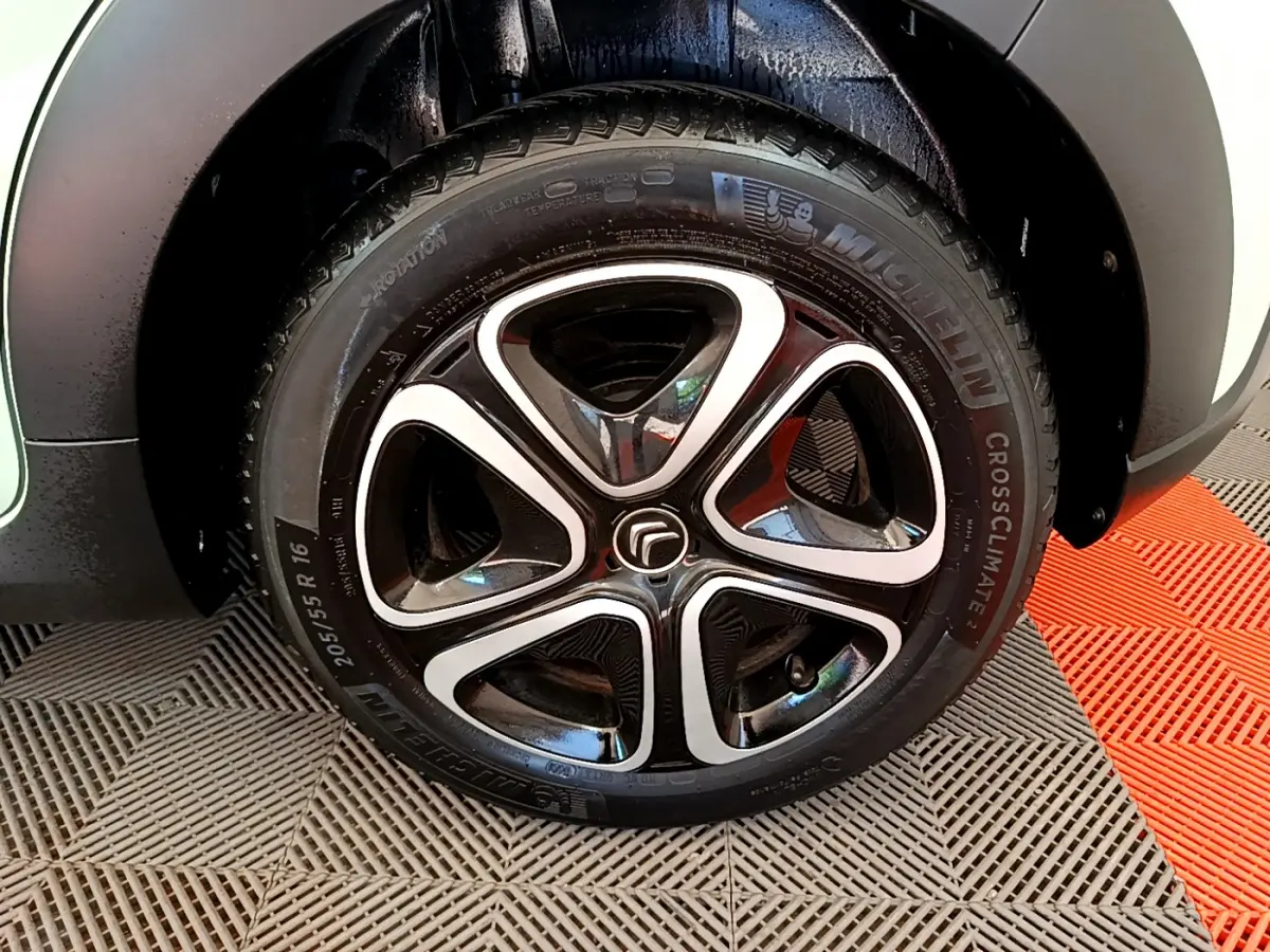 Gros plan sur la roue avant gauche de la Citroën C3 PureTech 82 S&S BVM Graphic verte avec jante alliage noire et argentée.