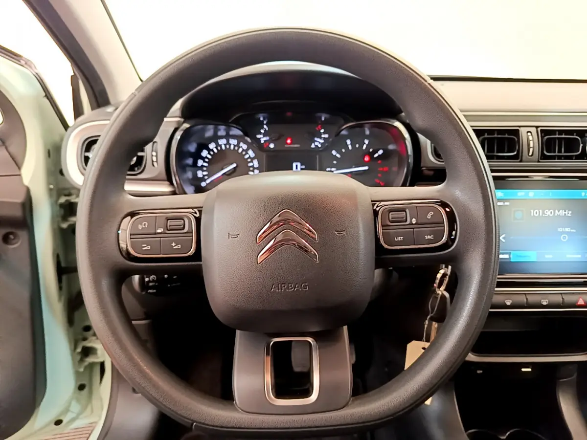 Vue centrée sur le volant noir de la Citroën C3 PureTech 82, avec tableau de bord et écran tactile visibles.