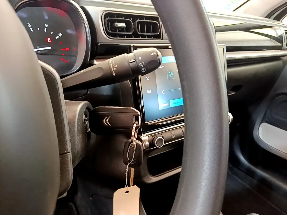 Intérieur de la Citroën C3 PureTech 82 vu côté conducteur, volant noir et écran tactile central allumé.