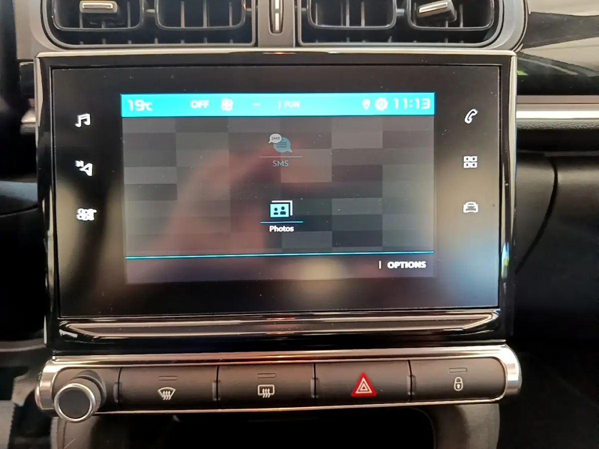 Écran tactile central affichant menu multimédia dans l'habitacle noir d'une Citroën C3 PureTech 2019.