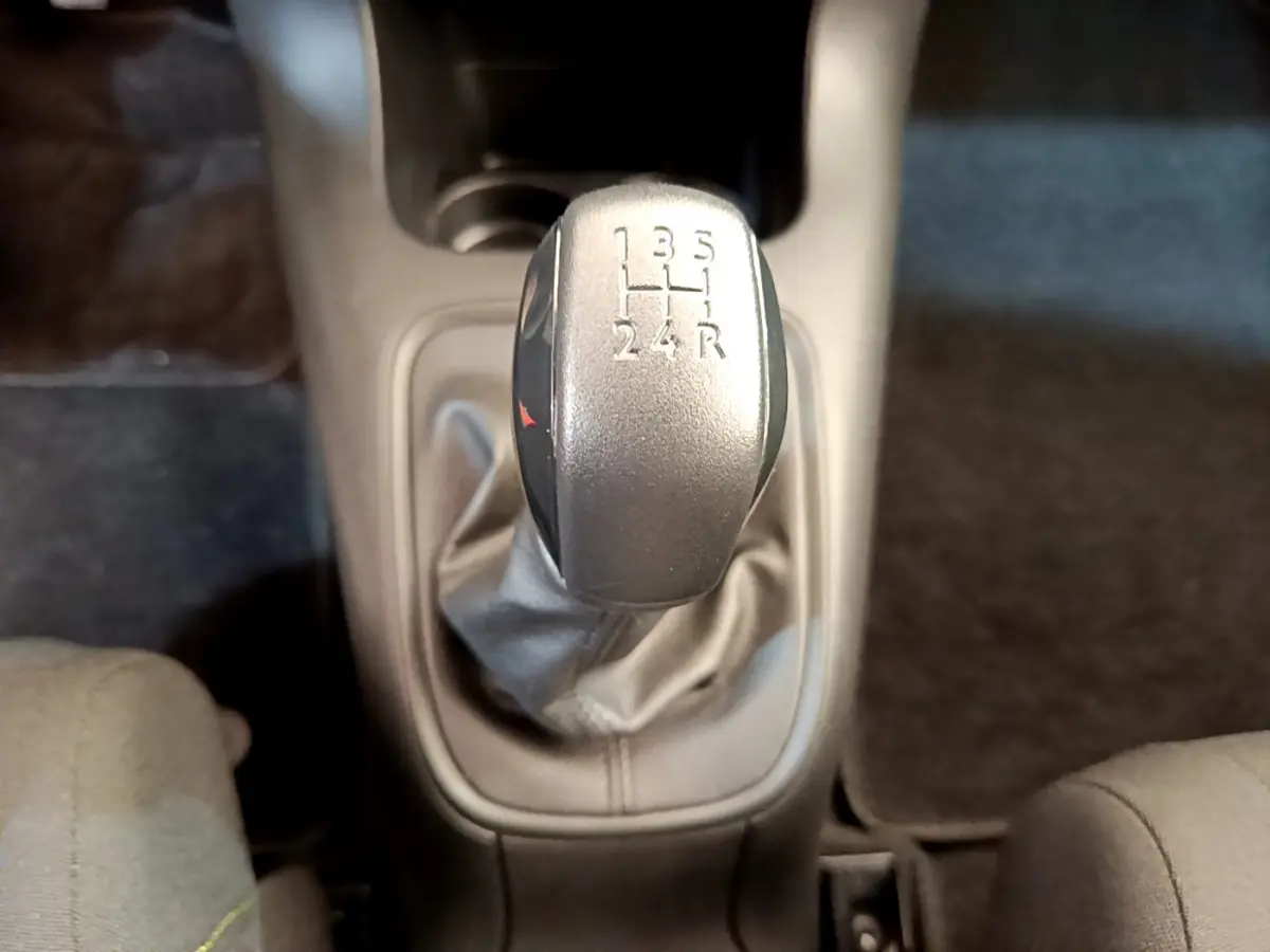 Le levier de vitesses manuel gris de la Citroën C3 PureTech 82 vu de dessus, entouré de sièges tissu gris.