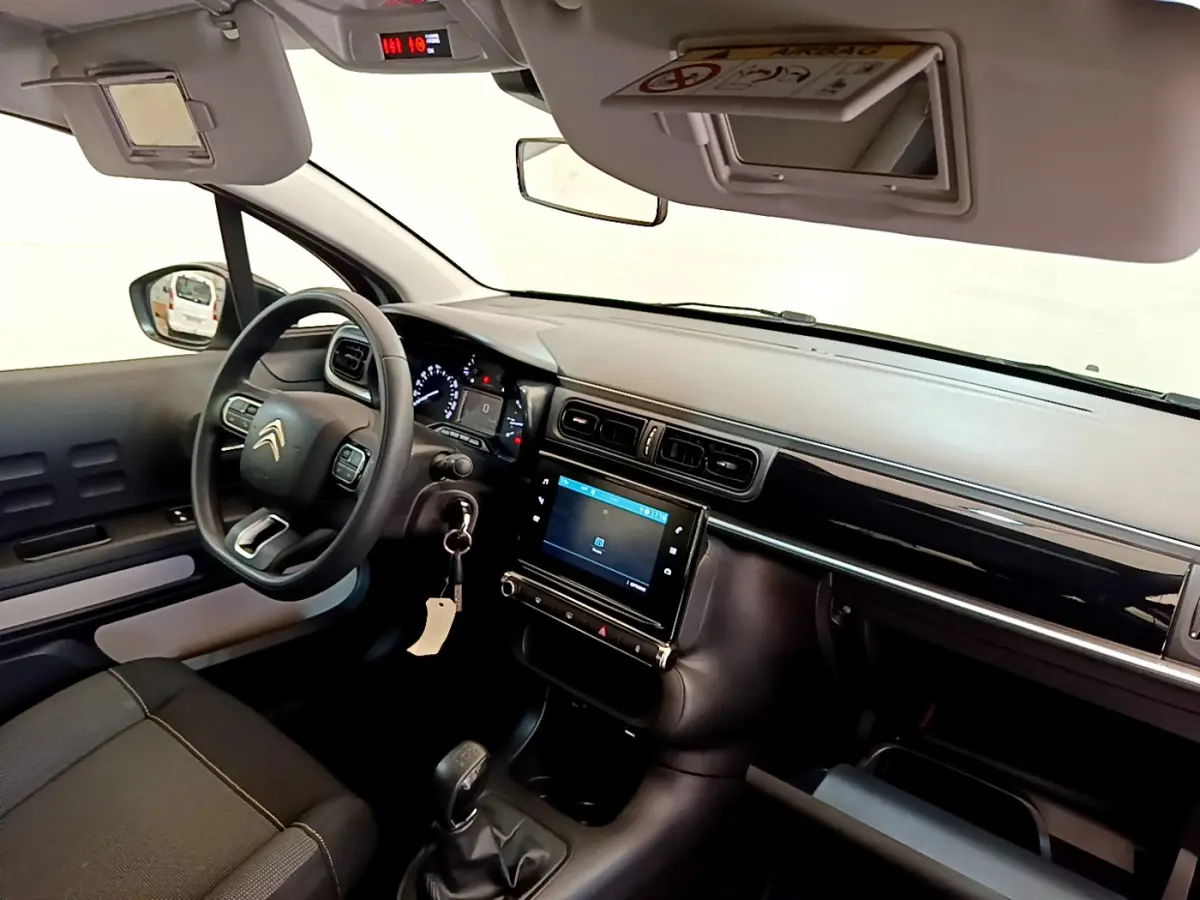 Intérieur de la Citroën C3 PureTech 82, vue côté conducteur montrant le tableau de bord noir et l'écran tactile central.
