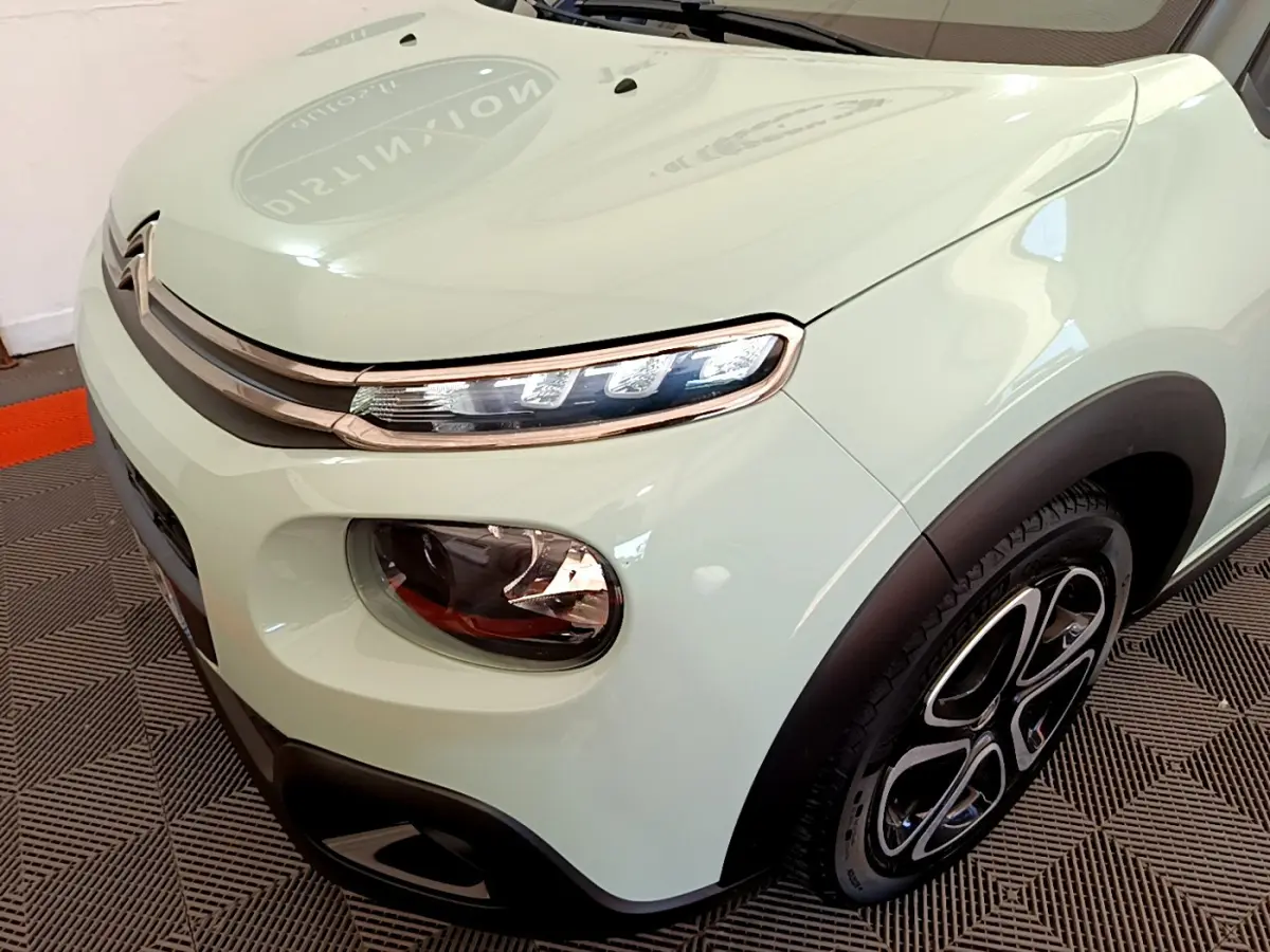 Vue 3/4 avant droit d'une Citroën C3 PureTech 82 vert clair avec phares LED et jantes noires stylisées.