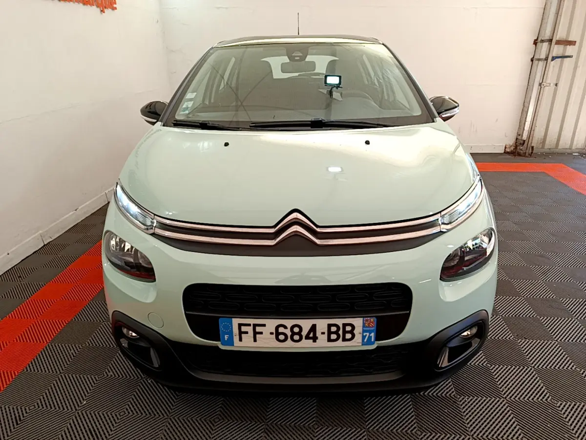 Vue frontale d'une Citroën C3 PureTech 82 S&S BVM Graphic vert clair avec calandre noire et phares LED allumés.
