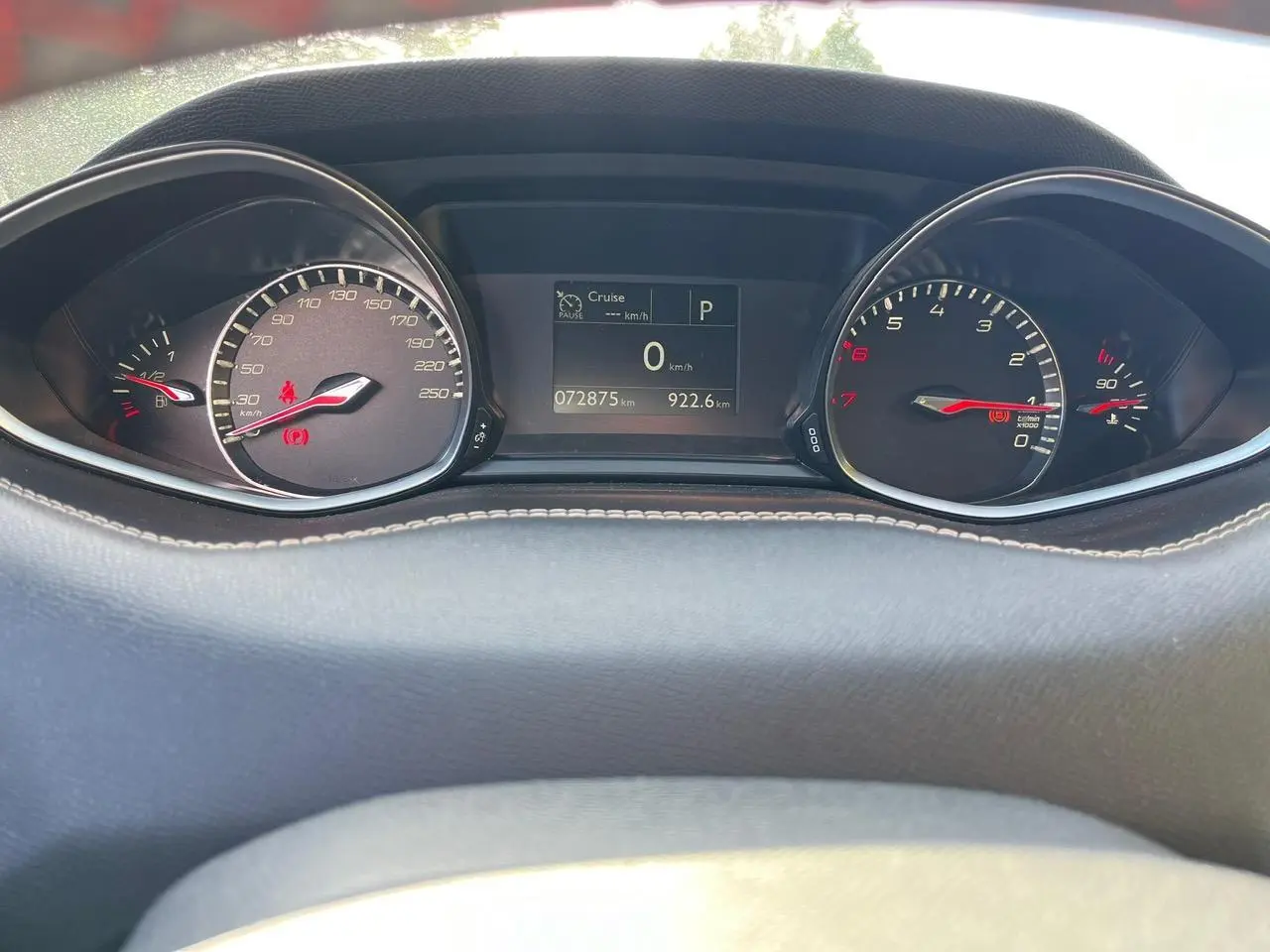 Tableau de bord de Peugeot 308 SW gris clair, affichage numérique central et compteurs analogiques éclairés.