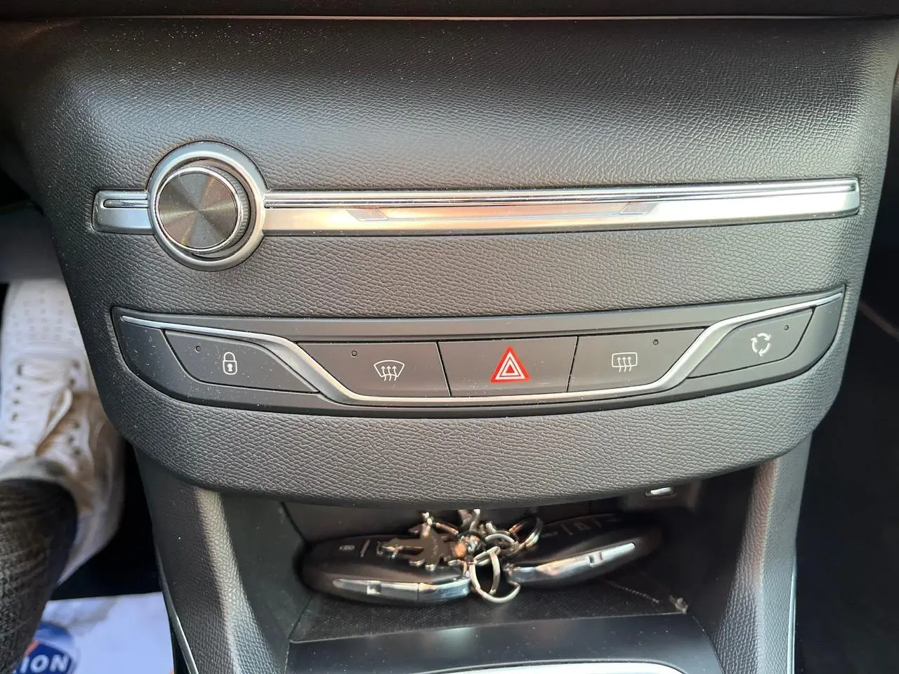 Gros plan sur la console centrale noire de la Peugeot 308 SW GT Line avec clés posées en bas.