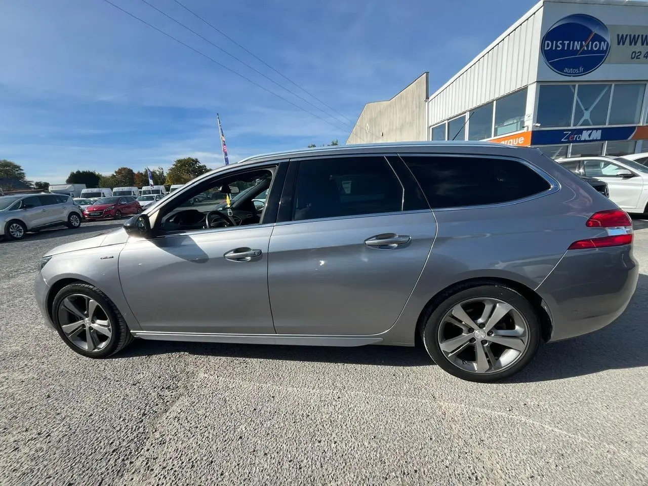 Profil côté gauche d'une Peugeot 308 SW gris clair 2019 avec jantes alliage 17 pouces diamantées Rubis.